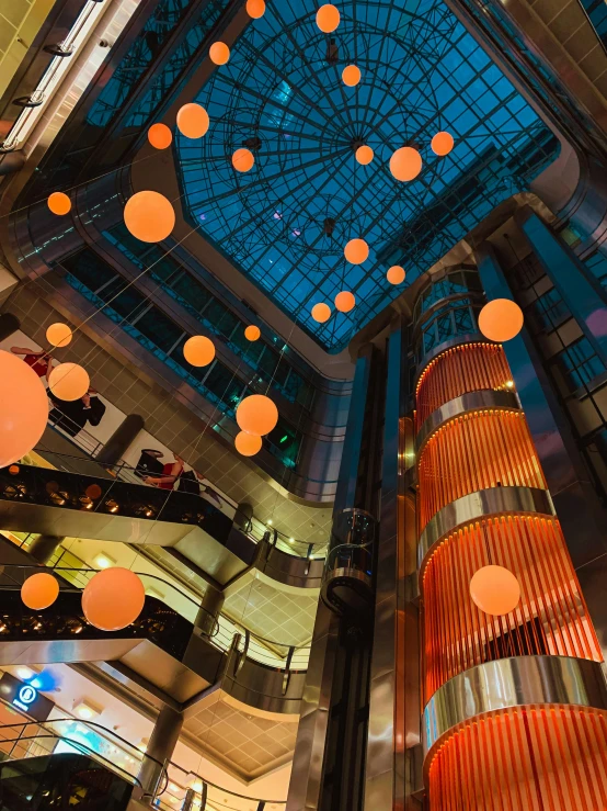 an atrium is illuminated with multiple colorful lanterns