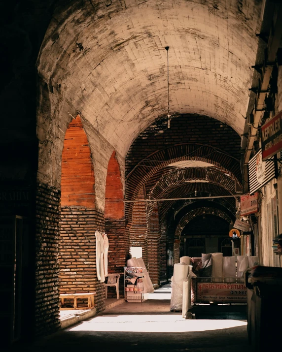 a brick archway that has a couch and chairs in it