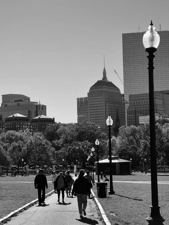 a person is walking down a road near a lamp post