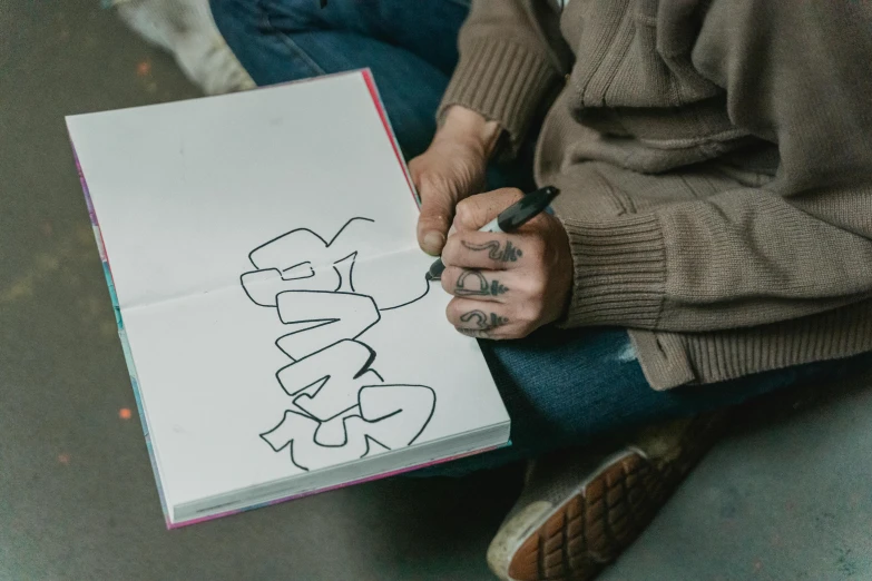 a woman holding a note and pencil writing a graffiti piece