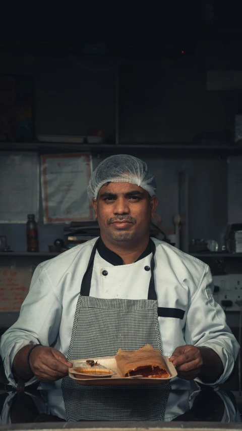 a man with a white hat holding some food