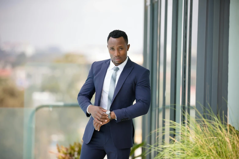 a man in a suit leaning against a building