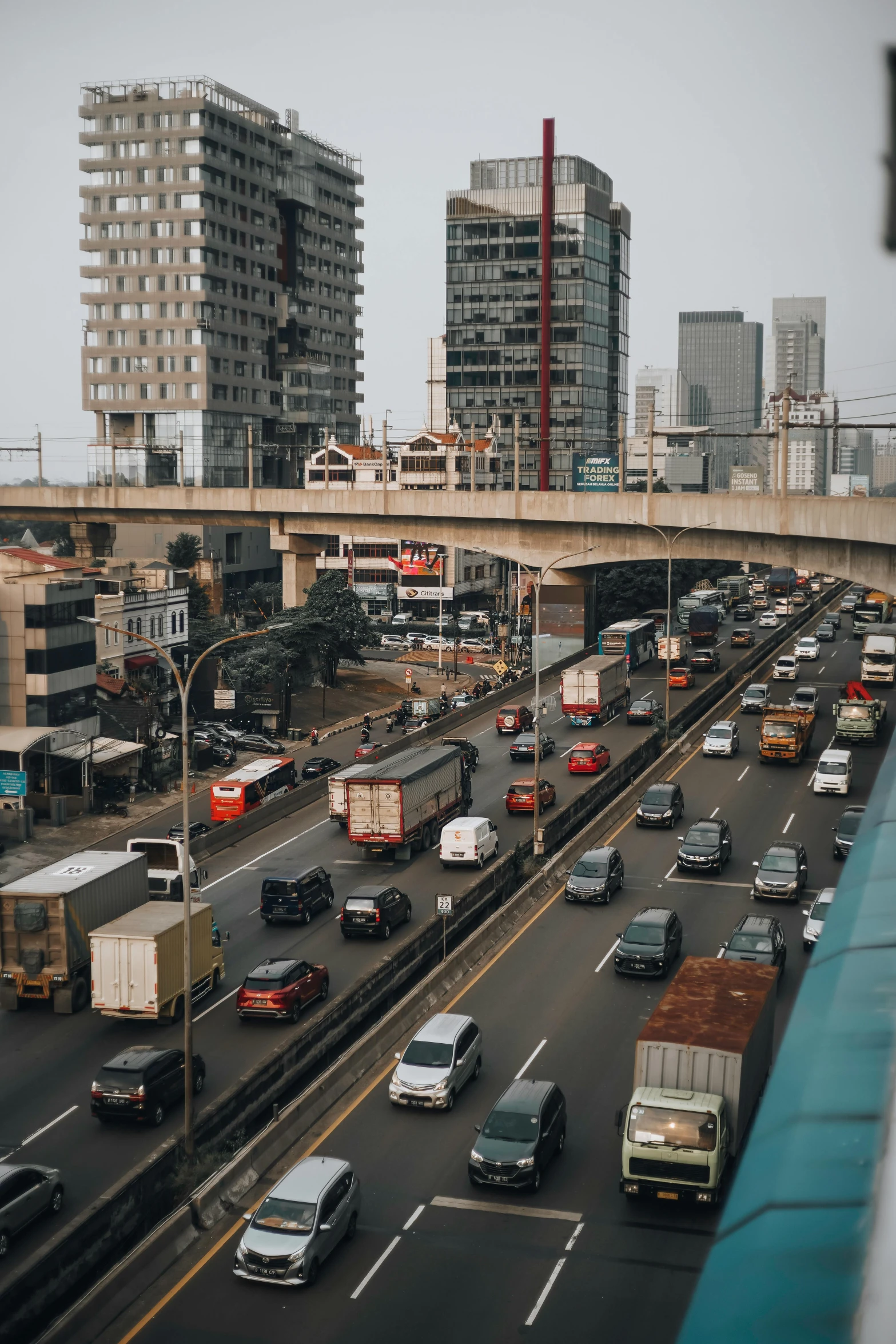 lots of traffic moving along the street under a bridge