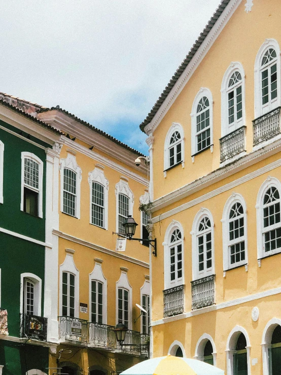 a yellow and green house with an umbrella