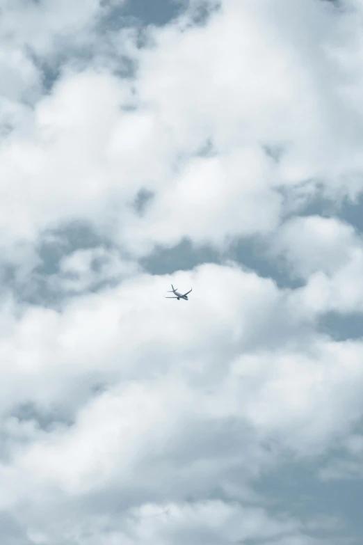 a commercial airplane flying through the clouds in a blue sky