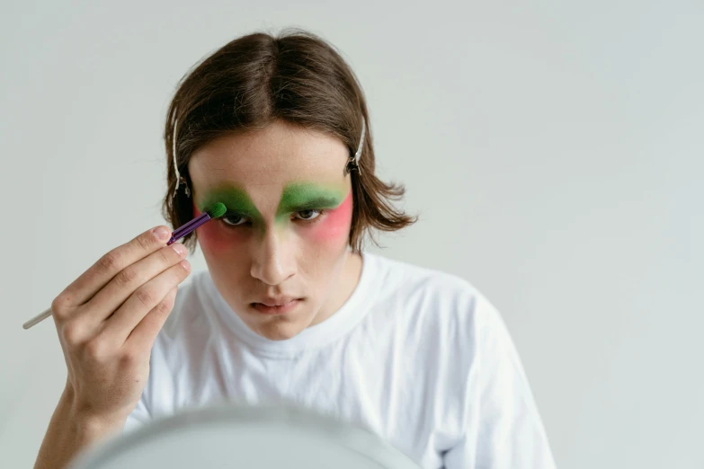 woman with makeup on looking in mirror with paint