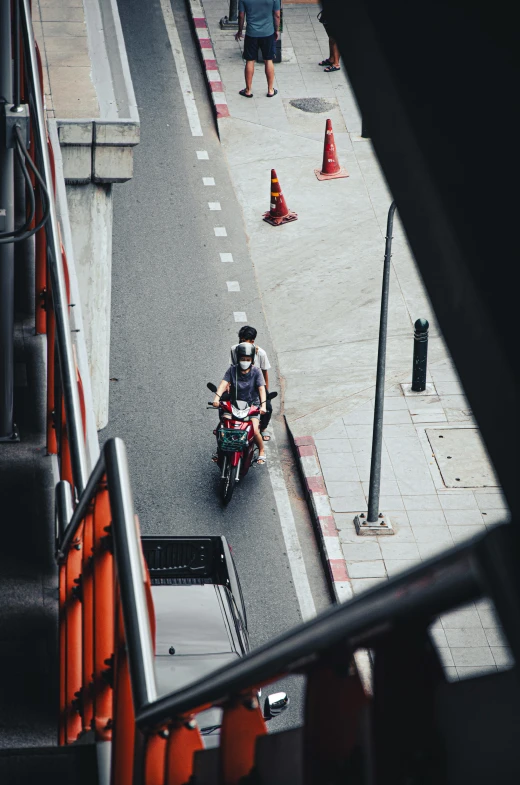 motorcyclist on roadway passing over barrier in city