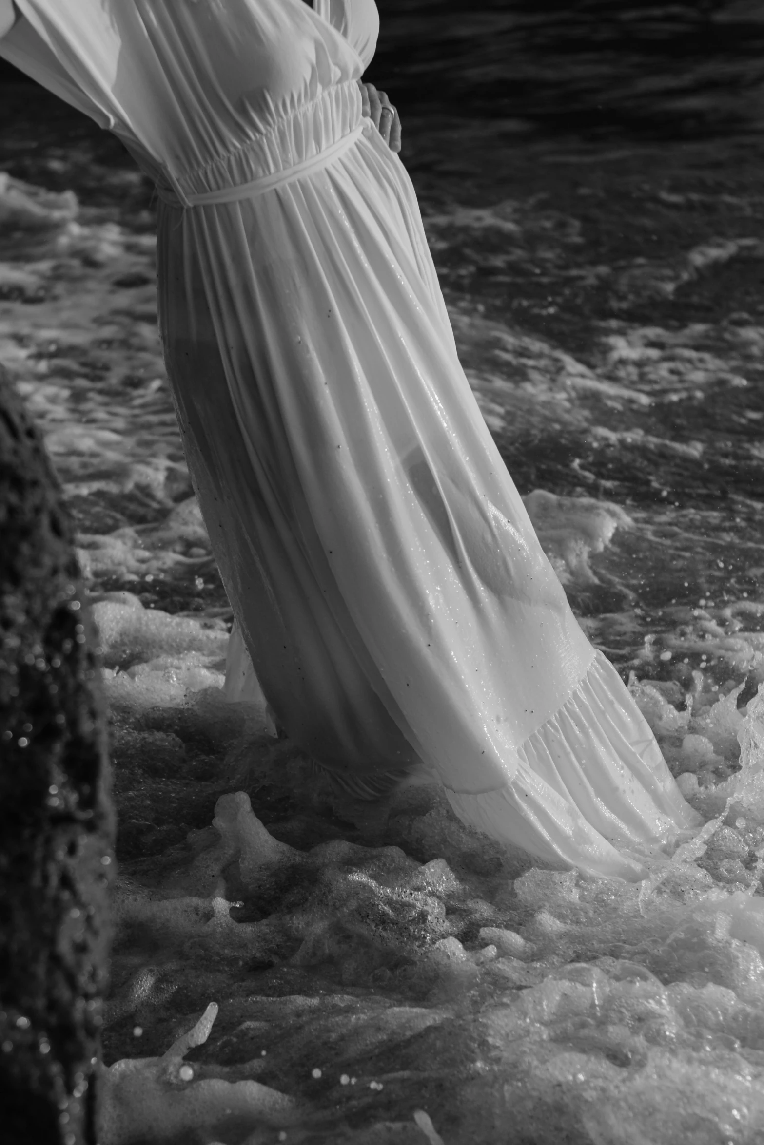 the woman is standing in the water at the edge of the shore