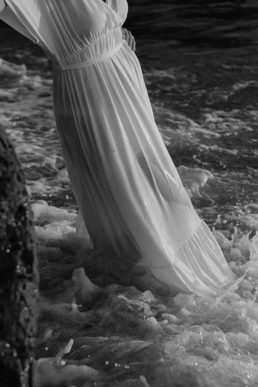 the woman is standing in the water at the edge of the shore