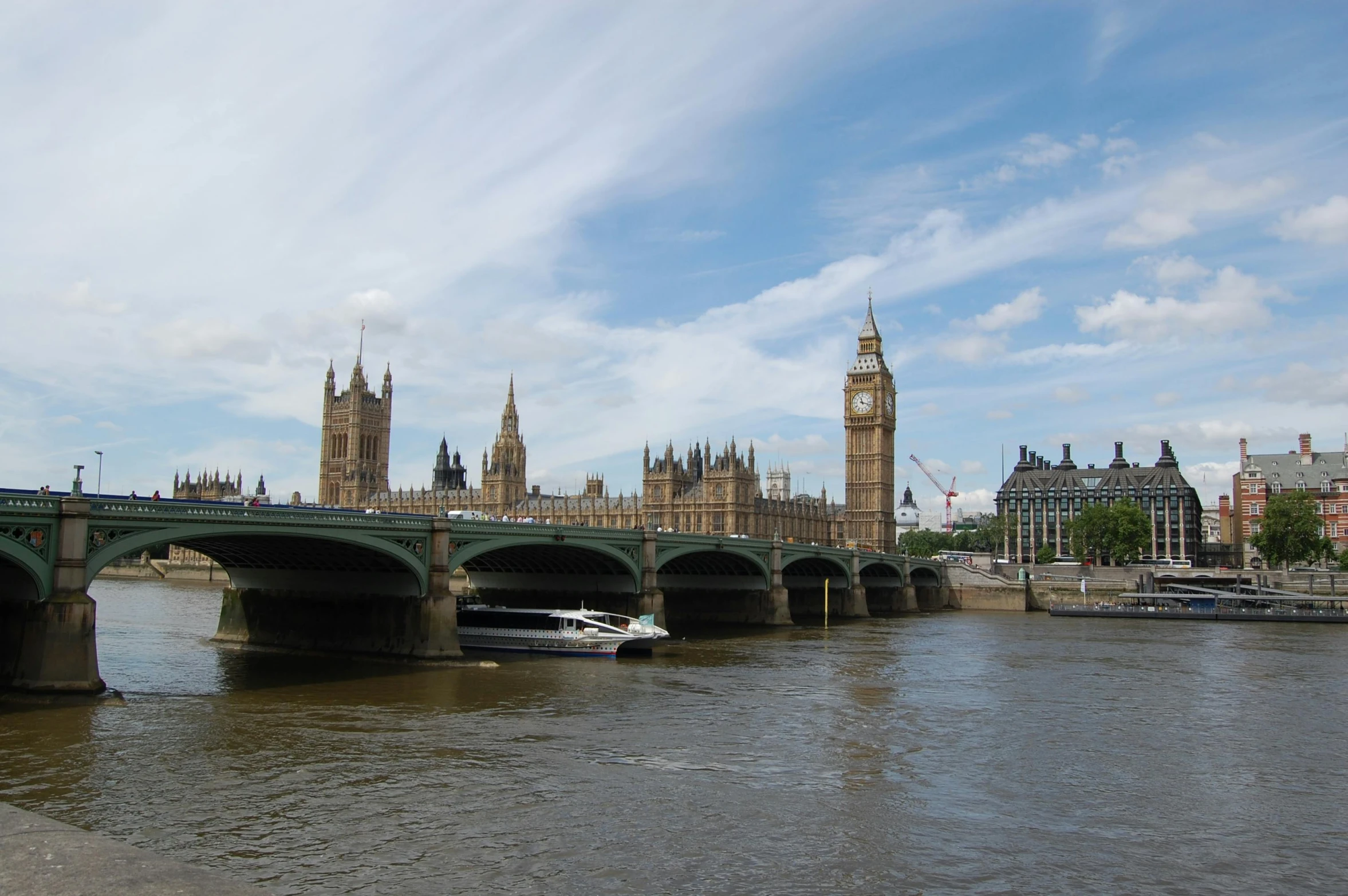 a river with a city skyline and a bridge over it