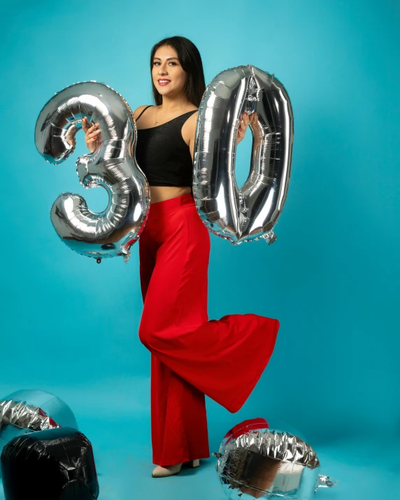 a woman is standing near some balloons and a drum