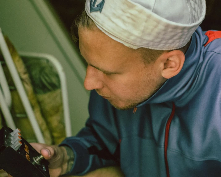 a man wearing a hat and looking at his phone