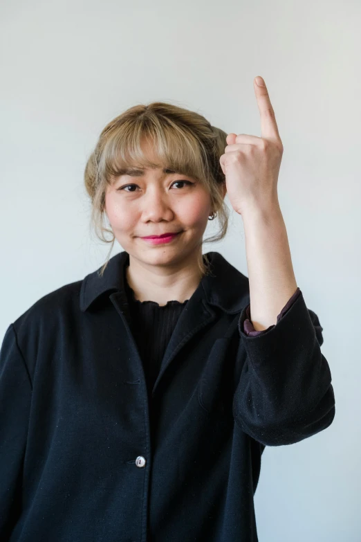 woman with two fingers up smiling and posing