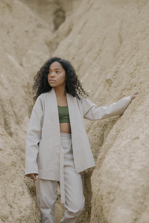 a woman stands near some huge mounds of sand