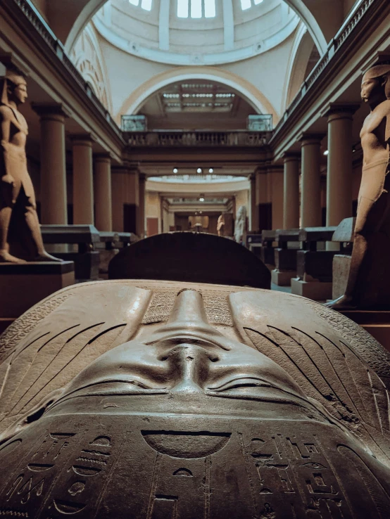 a sculpture of the body and head of a human being in an egyptian museum