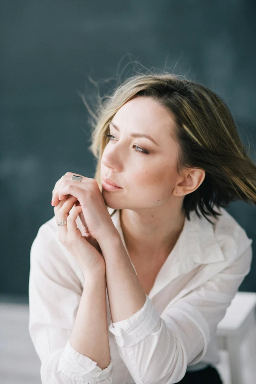 woman in white shirt leaning on a table