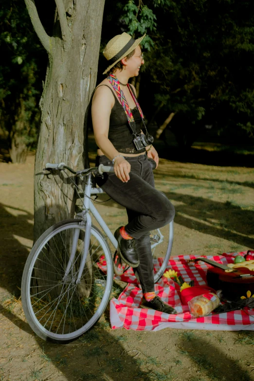 a girl sitting on the ground next to a bike