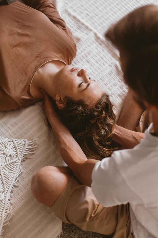 a woman is laying on the floor and getting her hair done