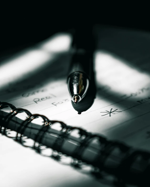 a pen is shown on top of a notebook