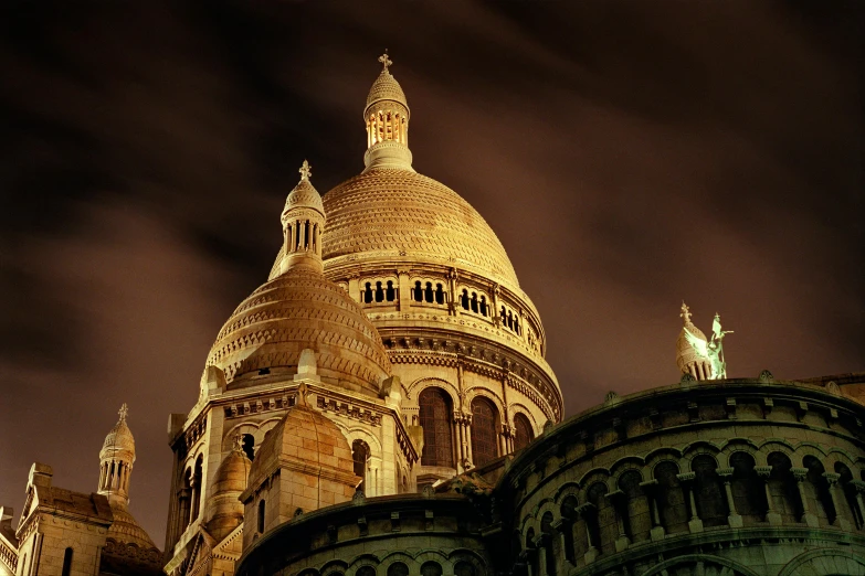 an ornate tower with angels atop is lit up by the light of the night