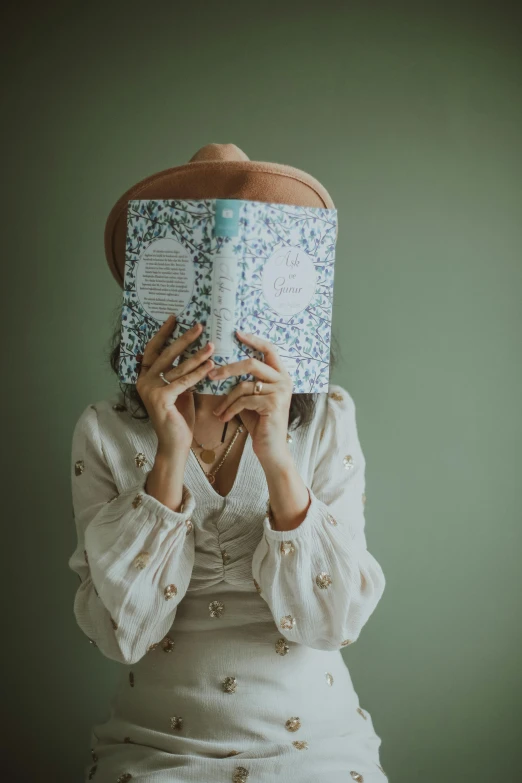 a woman covers her face with a book