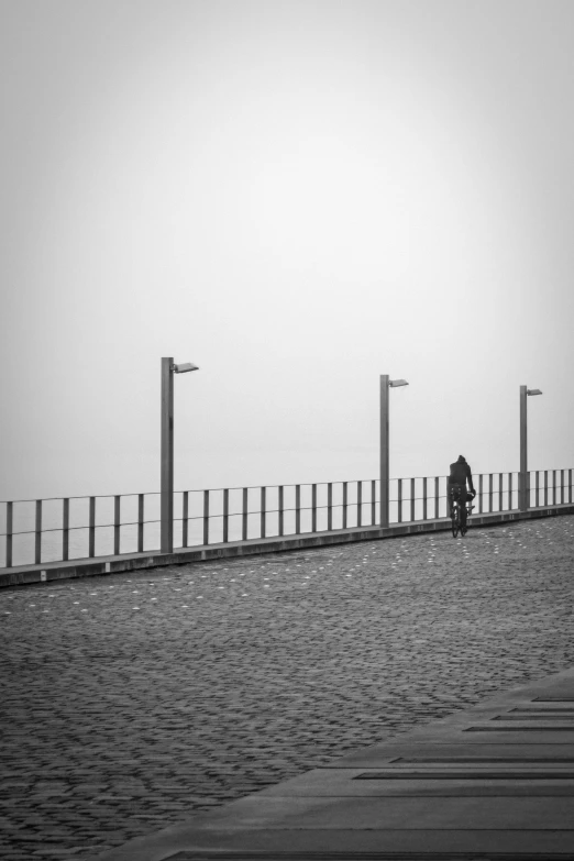 the biker is crossing the bridge over the water