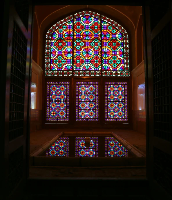 large stained glass window in a very dimly lit area