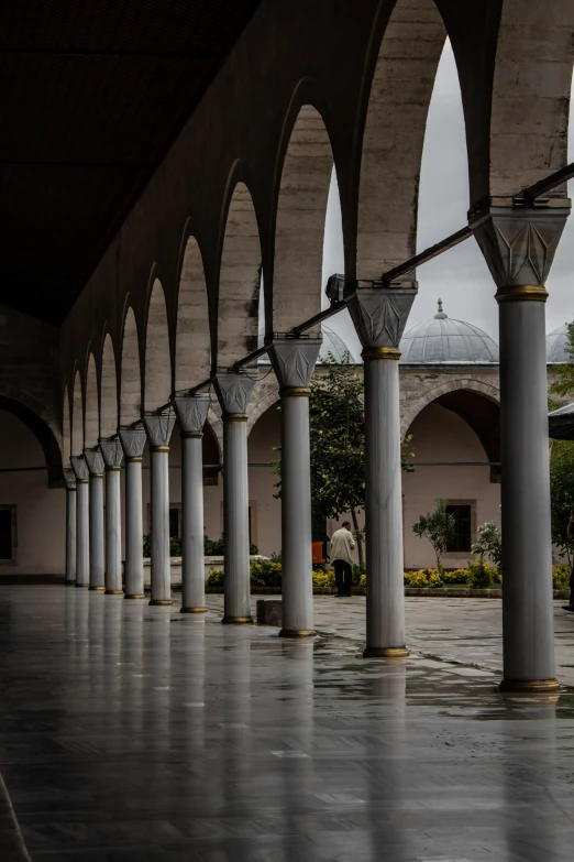 an indoor area with several stone arches and rows of columns