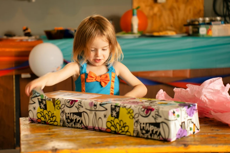 a small child standing at a table with a piece of cake in it