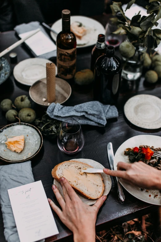 a hand that is holding food on top of a table