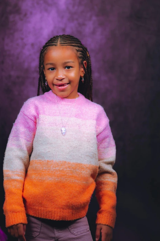 a smiling  in a pink and orange sweater