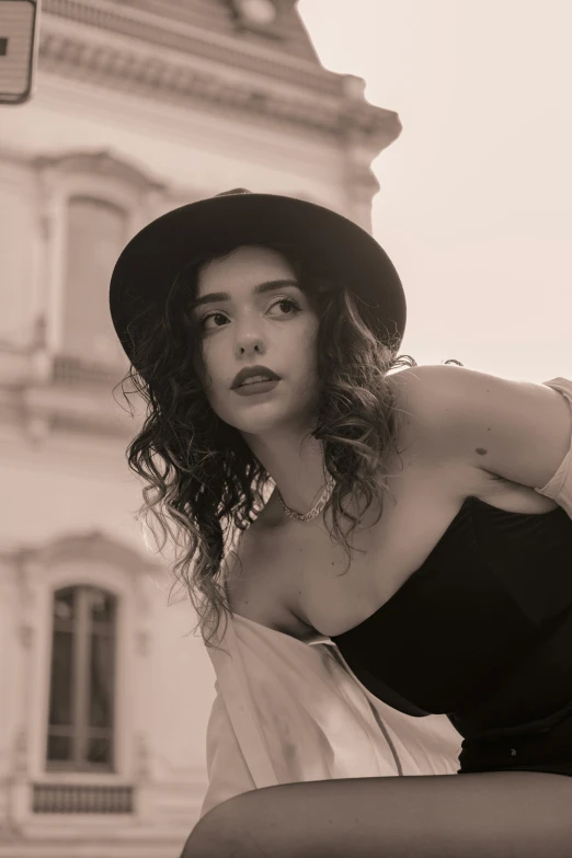 black and white pograph of woman with hat on bench