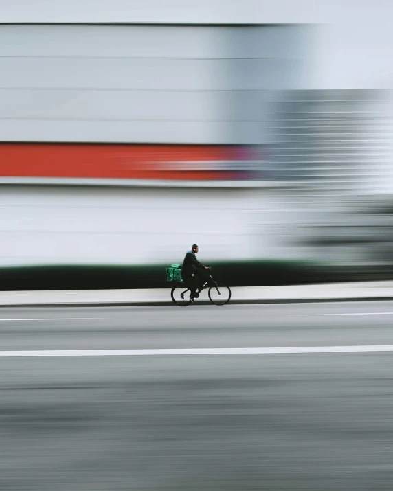 a man on a bike and his car speeding past