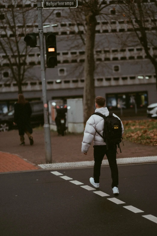 two people walk across the street from the building