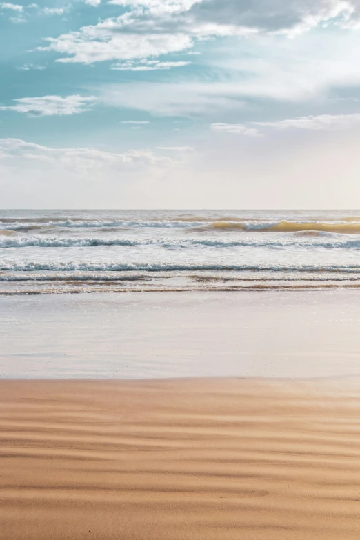 a surf board is on the beach and there is water