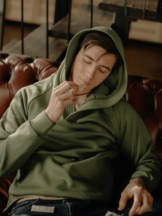 a person is in a green sweatshirt and eating