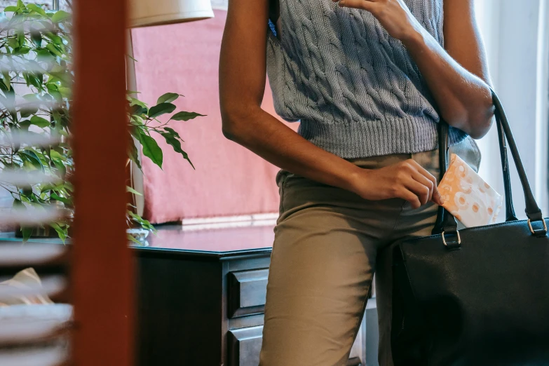 a woman holding a black purse while looking off into the distance