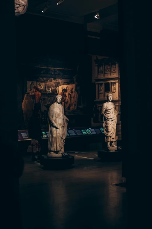 three statues that are sitting in a dark room