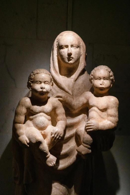 the sculpture of the person and the two children