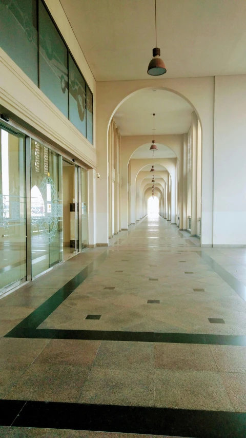 an empty hallway with many windows and doors