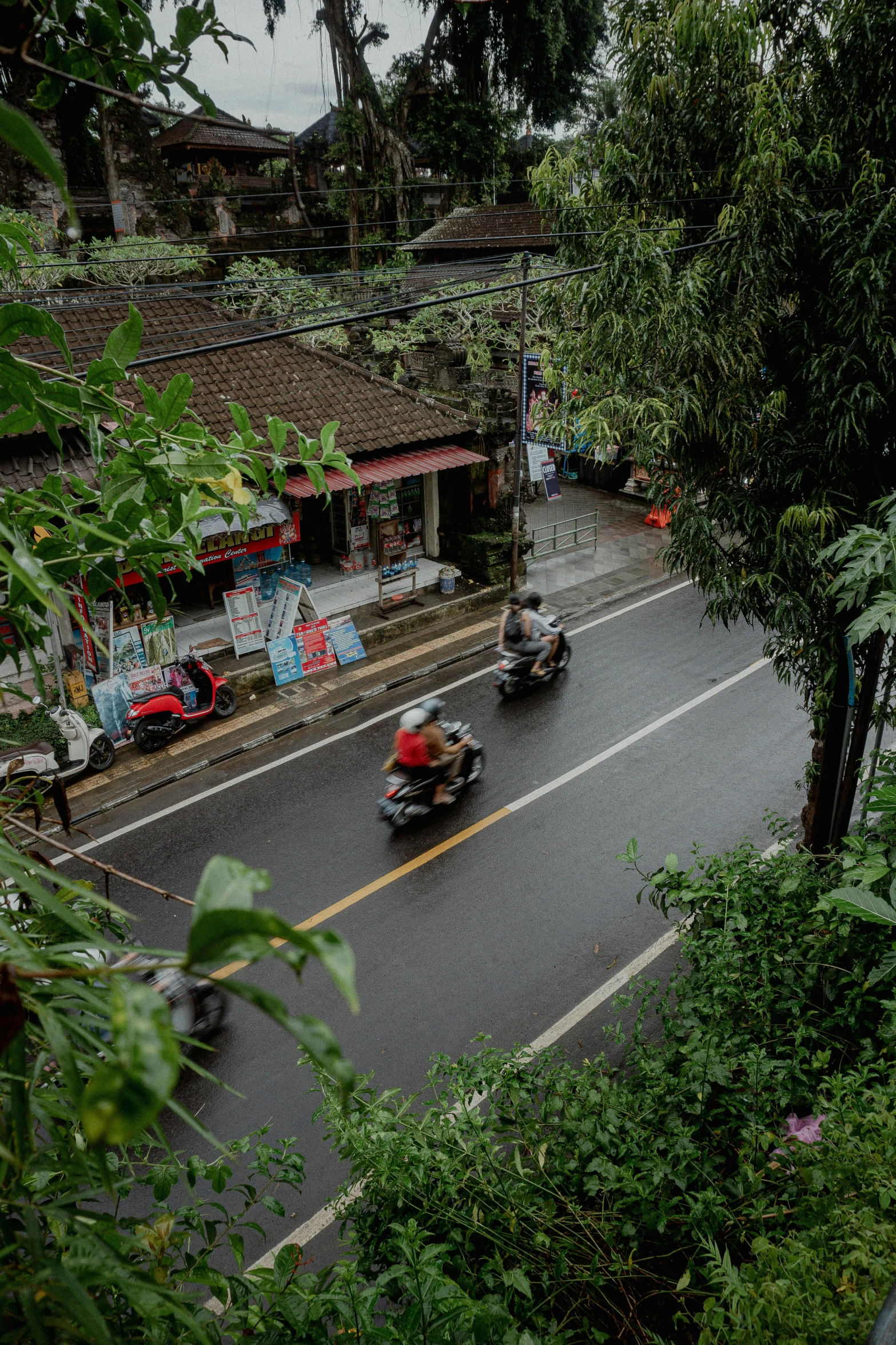 the people on motorcycles are riding in the rain