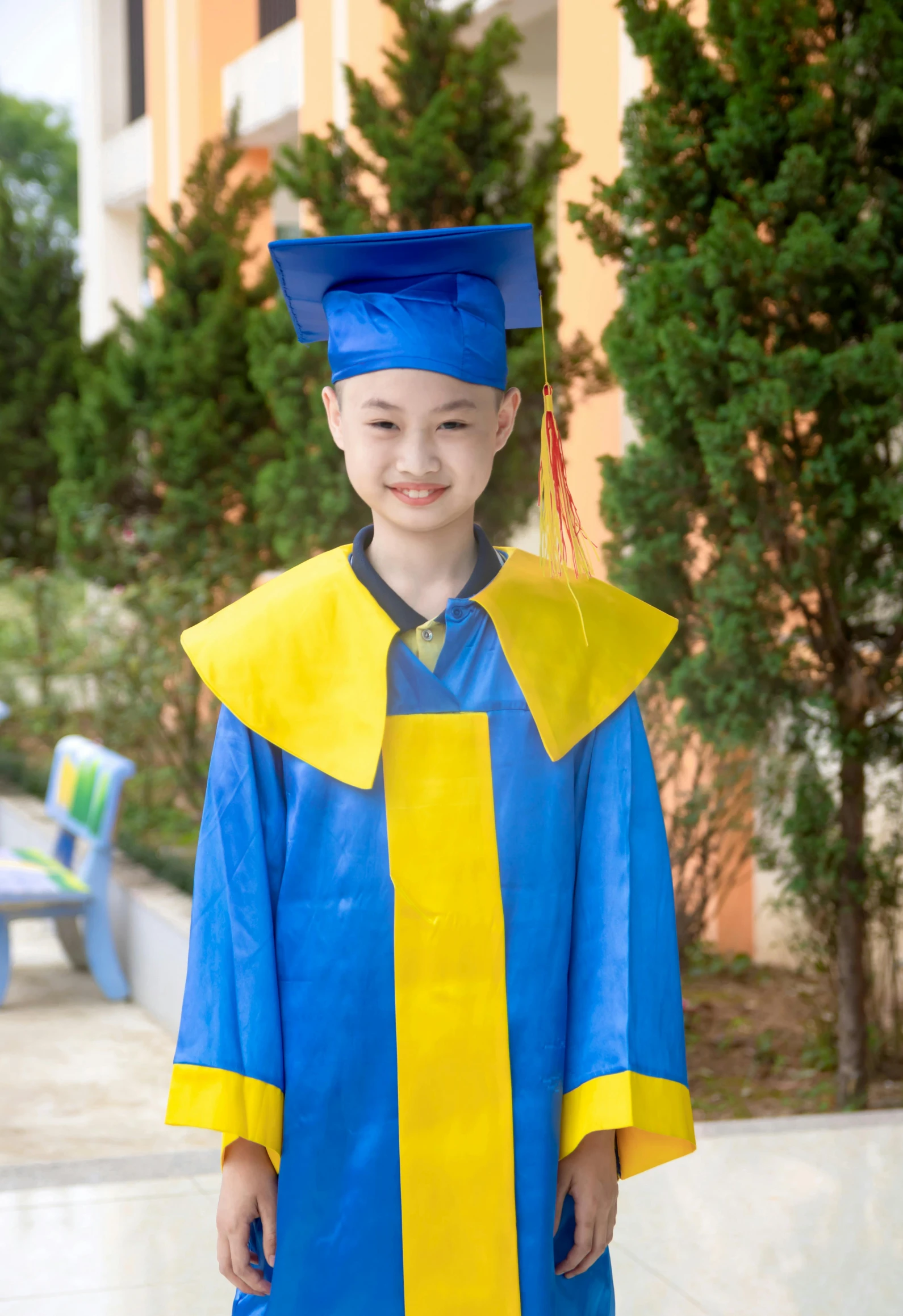  in cap and gown standing next to outdoor table