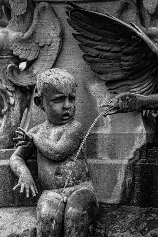 an angel statue sitting on the side of a stone pillar