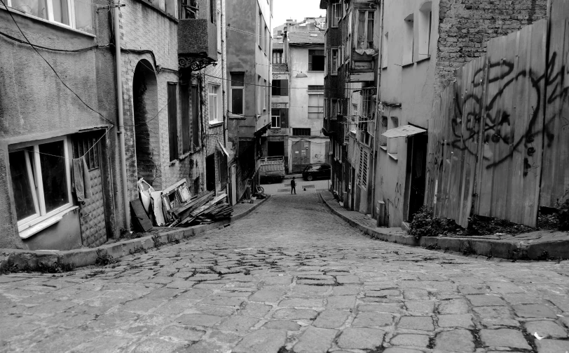 a narrow alley with a graffiti - covered building on both sides