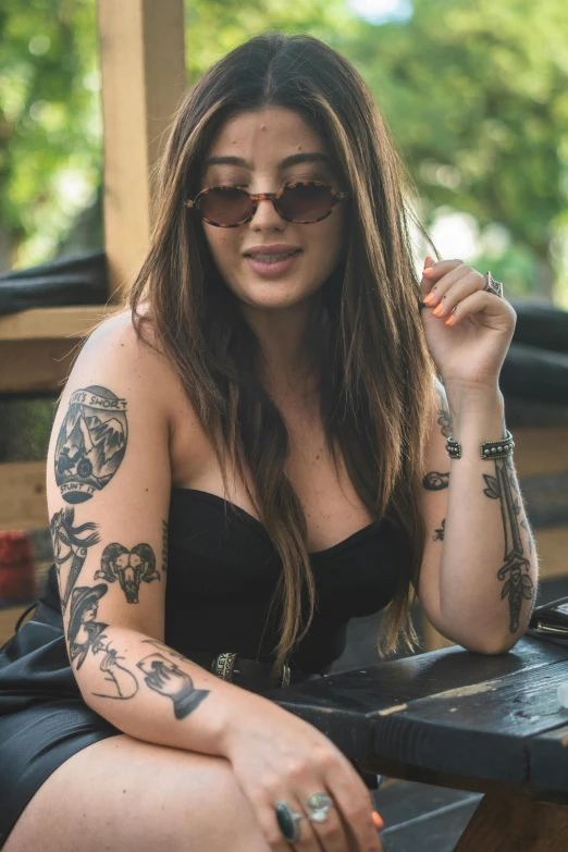 a woman with tattoos on her arm and her hand is sitting on a chair