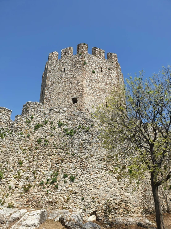 a stone tower has a window near the base of it