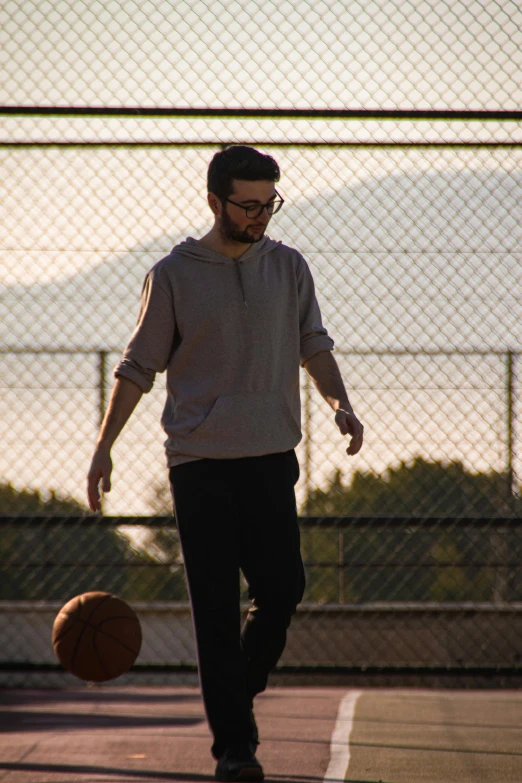 a man standing on top of a basketball court holding a basketball