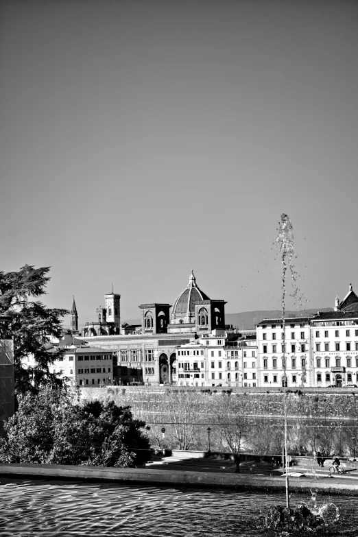 some water buildings trees and dirt a clock tower