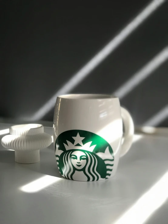 starbucks logo coffee cup on white surface next to plastic spirals