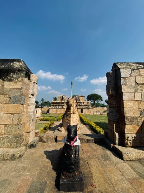 a dog sitting at the foot of a statue